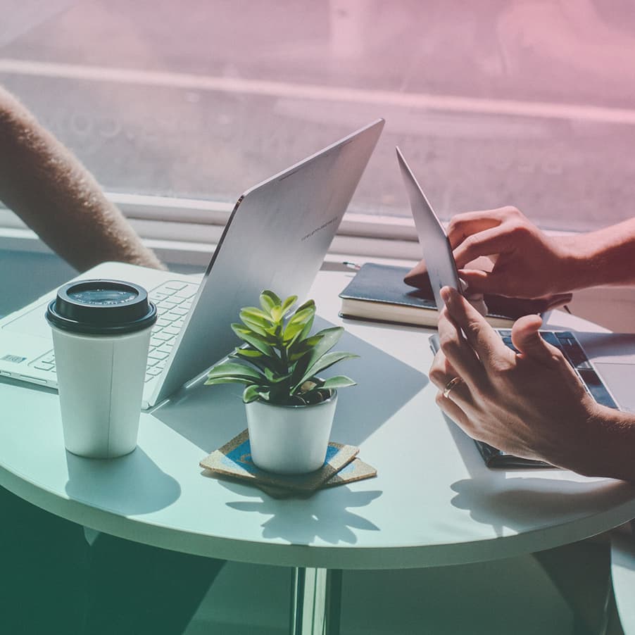 Two people using laptops in a cafe