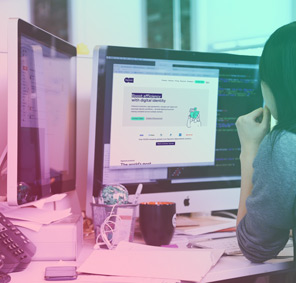 A women studying the Signicat website on a computer screen