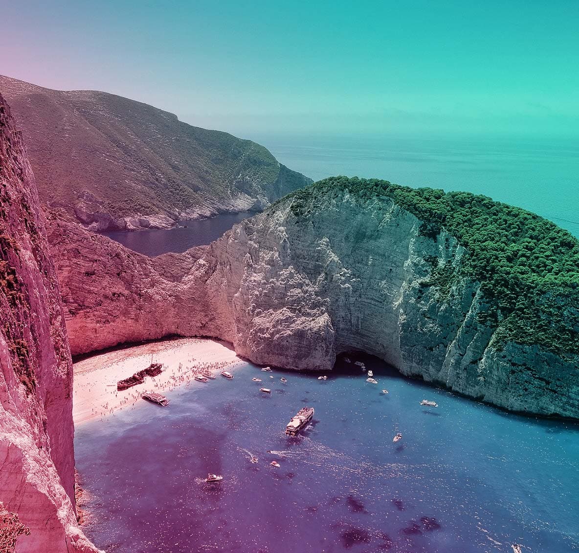 Aerial view of holidaymakers visiting a shipwreck in a sandy cove